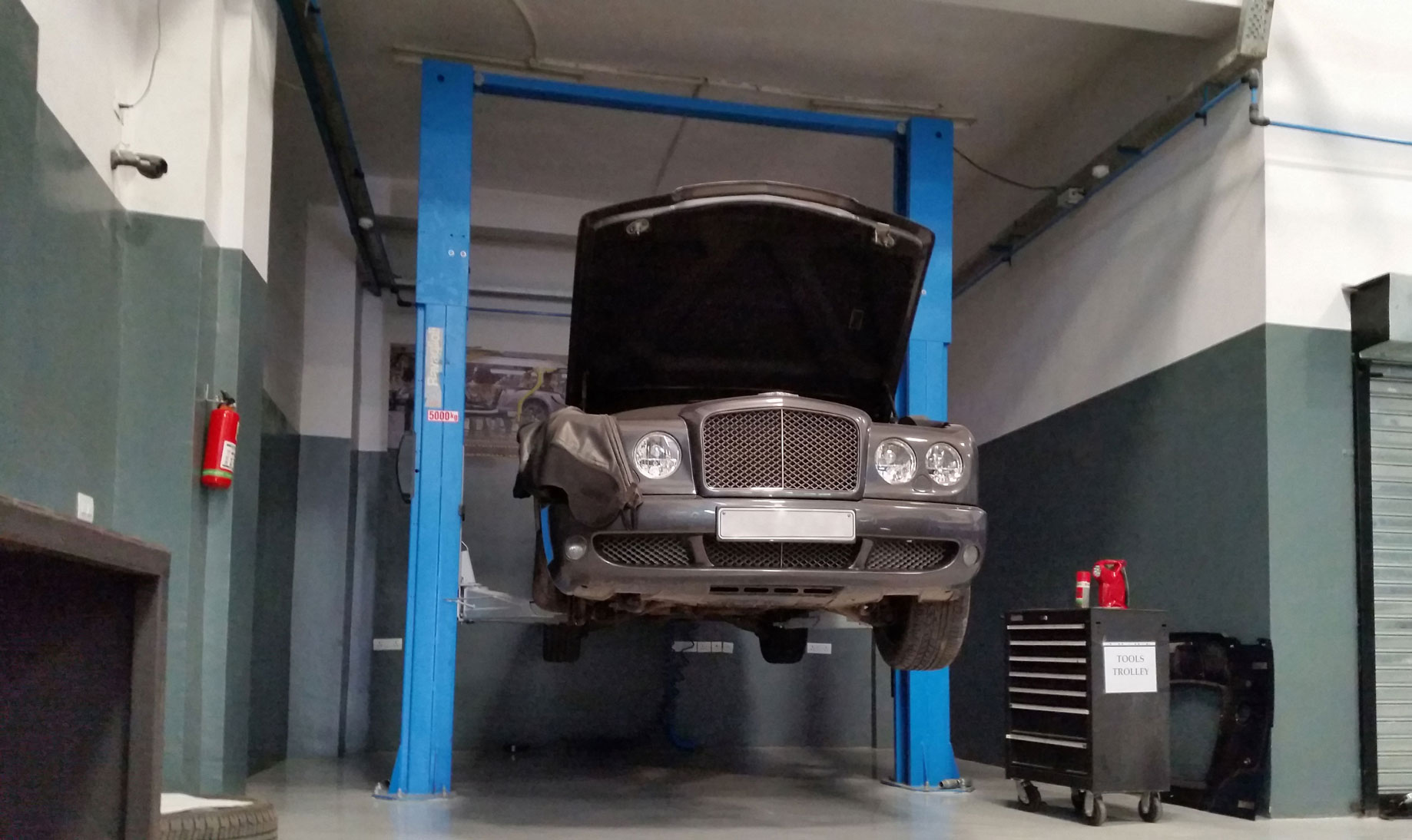 Car is lifted by a Ravaglioli 2-post lift with a load capacity of 5000 kg