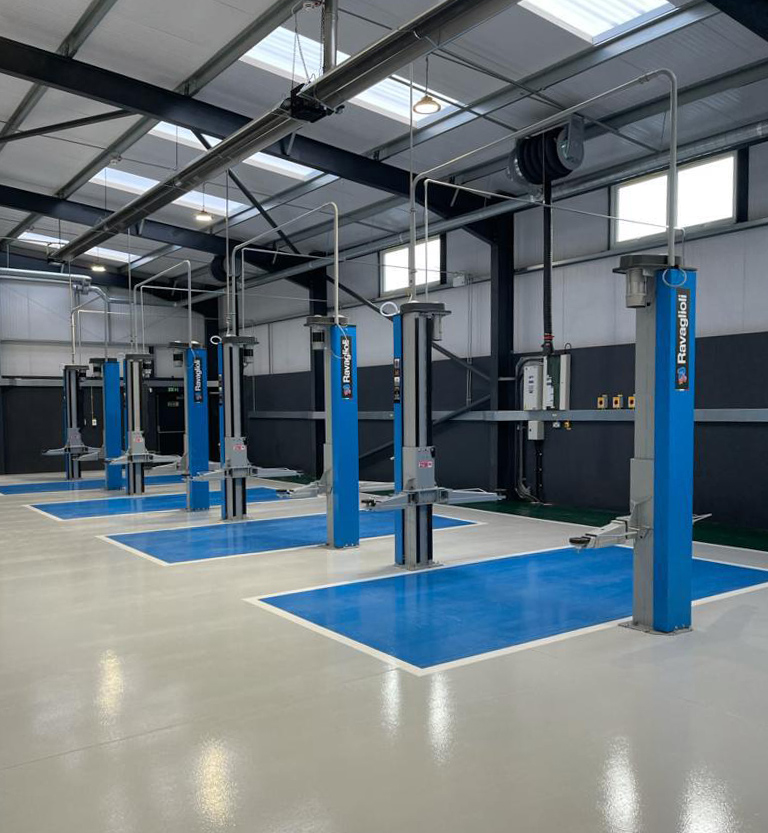 Four Ravaglioli blue car lifts located in a college workshop