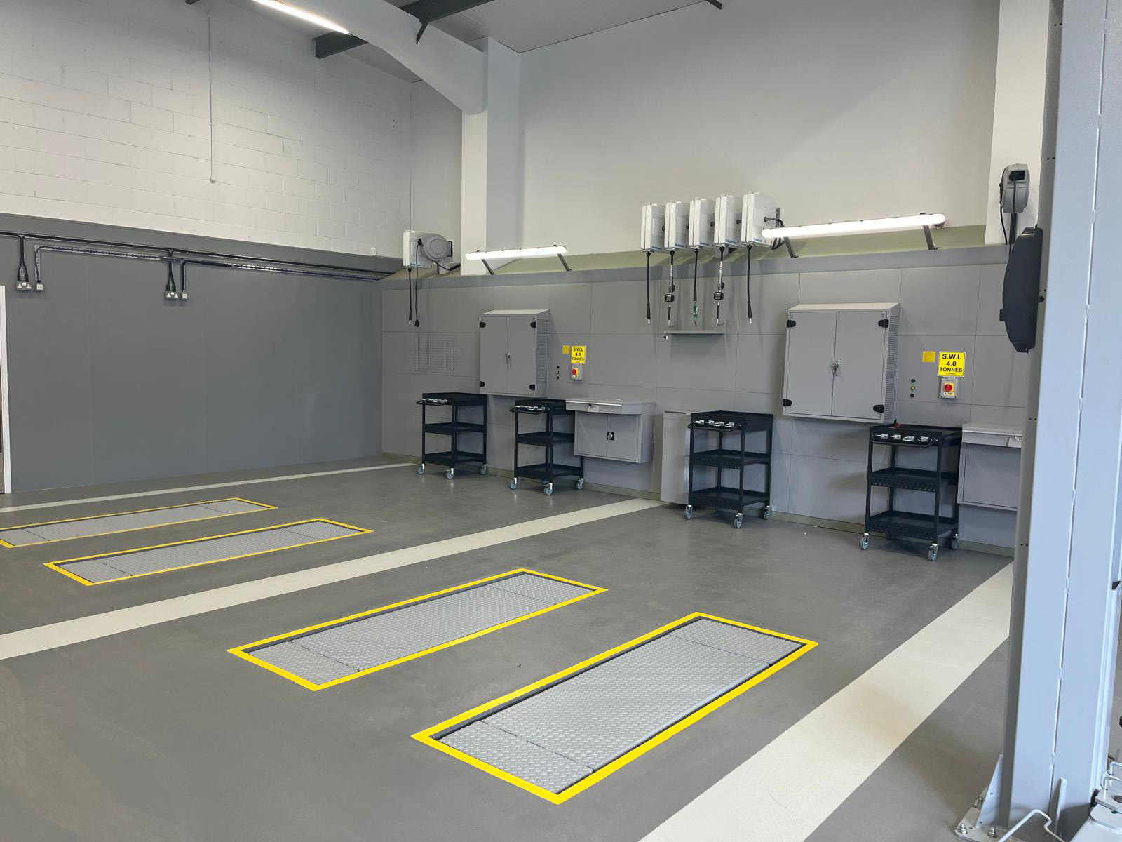 Pair of gray car double scissor lifts installed in a machine shop